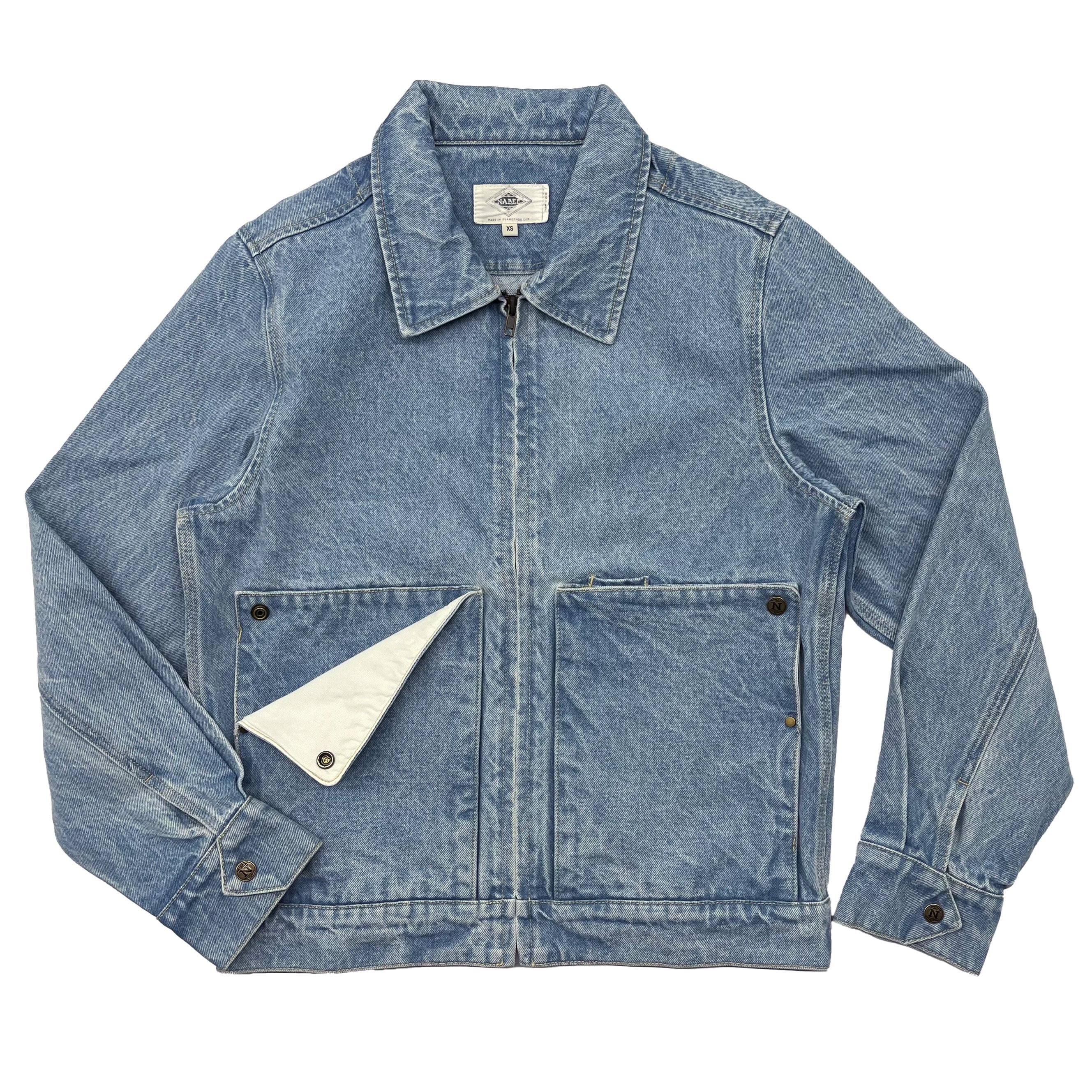 A light blue denim jacket with a front zipper, two large flap pockets, and a white interior lining visible at the collar, shown flat on a white background.